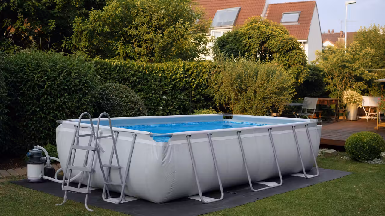 Piscine hors-sol tubulaire rectangulaire installée sur une pelouse plane dans un jardin familial lumineux