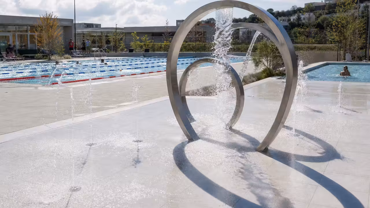 Aire de jeux d’eau avec jets au bord d’un bassin de natation dans une piscine publique rénovée