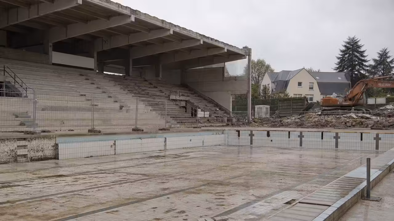 Bâtiment d’une ancienne piscine municipale des années 1970 en cours de démolition, sous un ciel normand