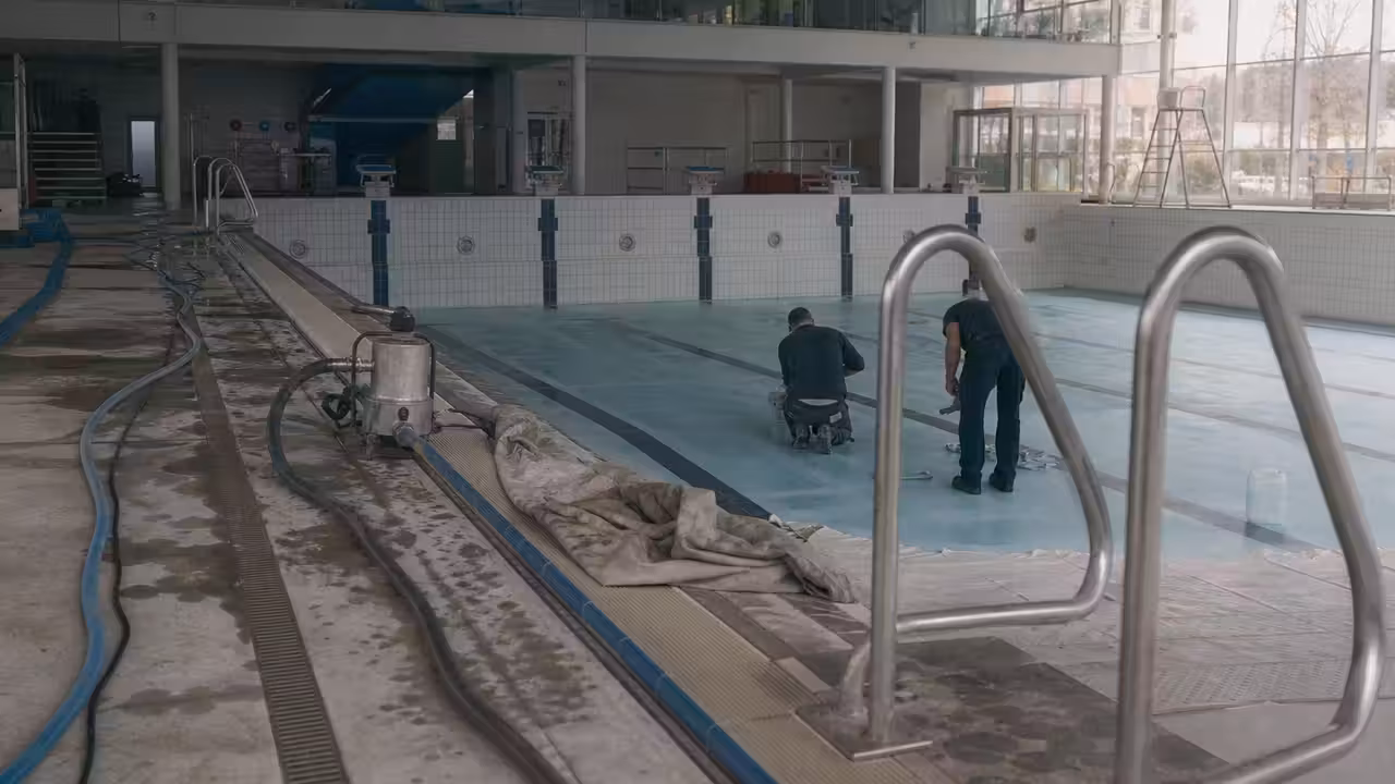 Bassin de piscine municipale vide pendant une intervention technique sur le revêtement et les équipements