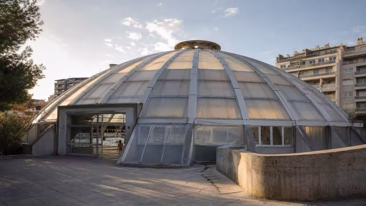 Coupole arrondie d’une piscine Tournesol municipale avec ses arcs métalliques et ses panneaux translucides