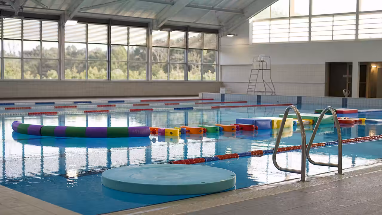 Bassin couvert d’une piscine municipale préparé pour une animation aquatique familiale avec lignes d’eau et jeux flottants