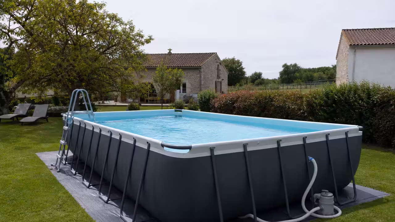 Piscine hors-sol tubulaire familiale installée sur un jardin nivelé, avec filtration et espace sécurisé