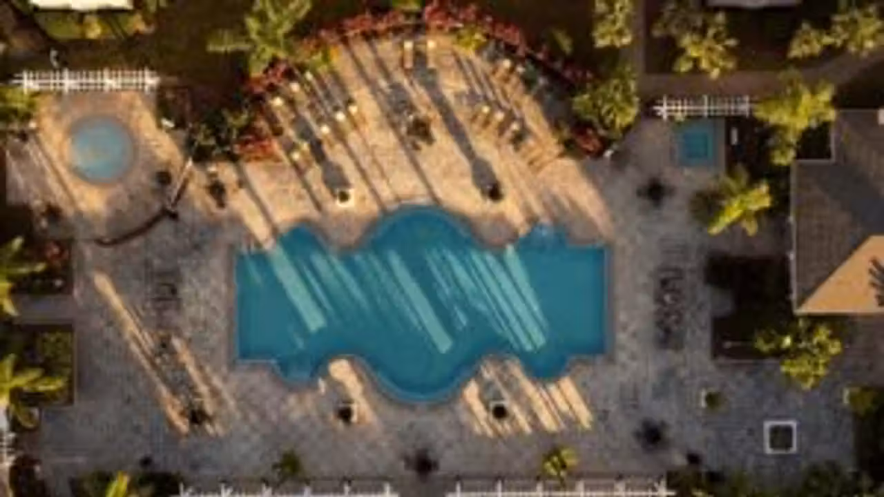 Bassin municipal vide en rénovation, avec plages déposées et équipements techniques visibles en arrière-plan